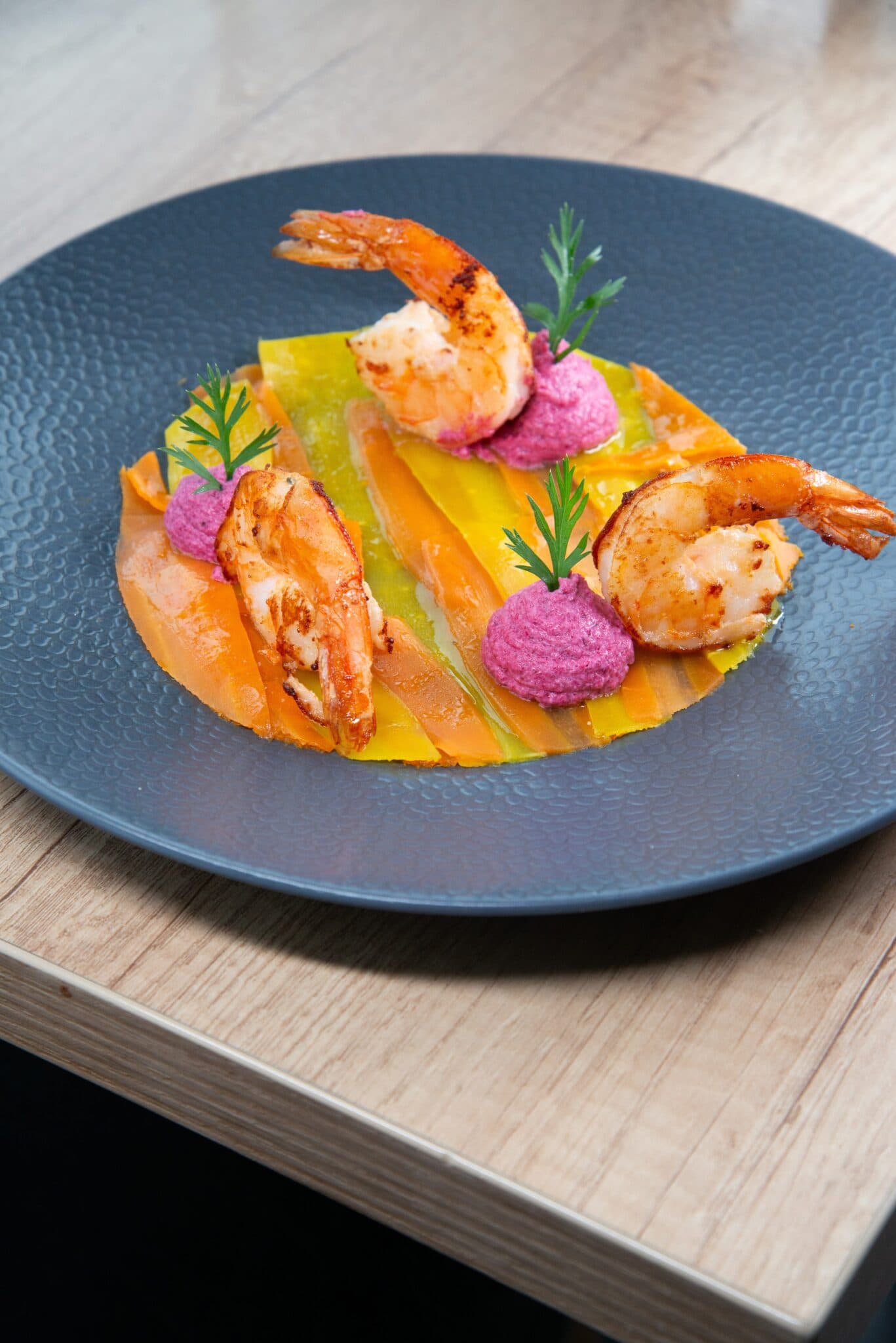 Crevettes dressées sur une assiette bleu nuit, au restaurant Le Savoyard